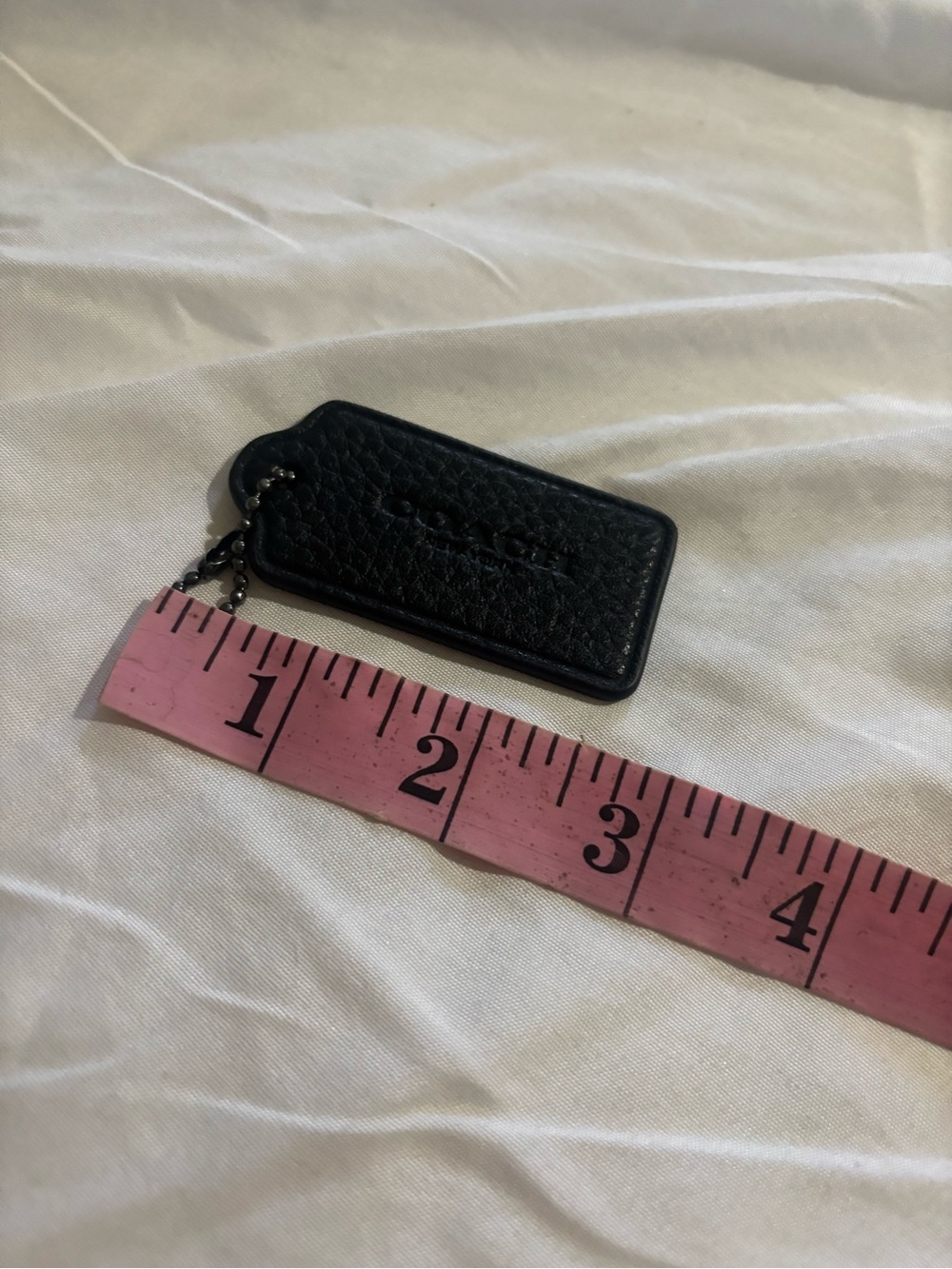 Coach black pebbled leather hang tag